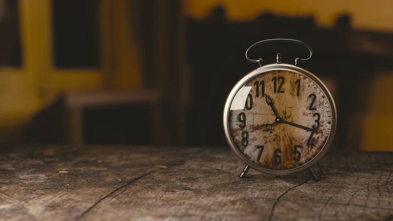 Selective Focus Photography Gray Analog Clock on Black Surface