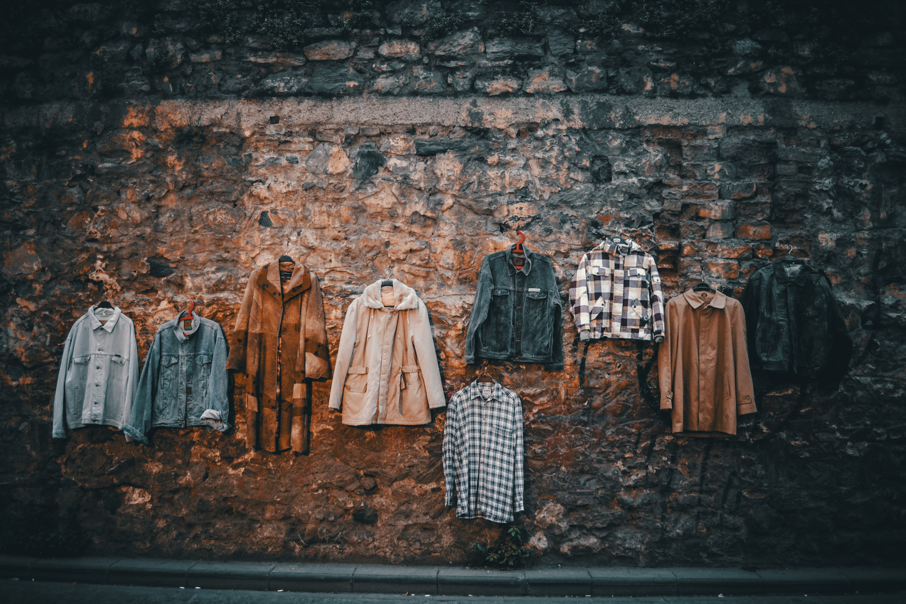 Hangers with clothes on old street wall