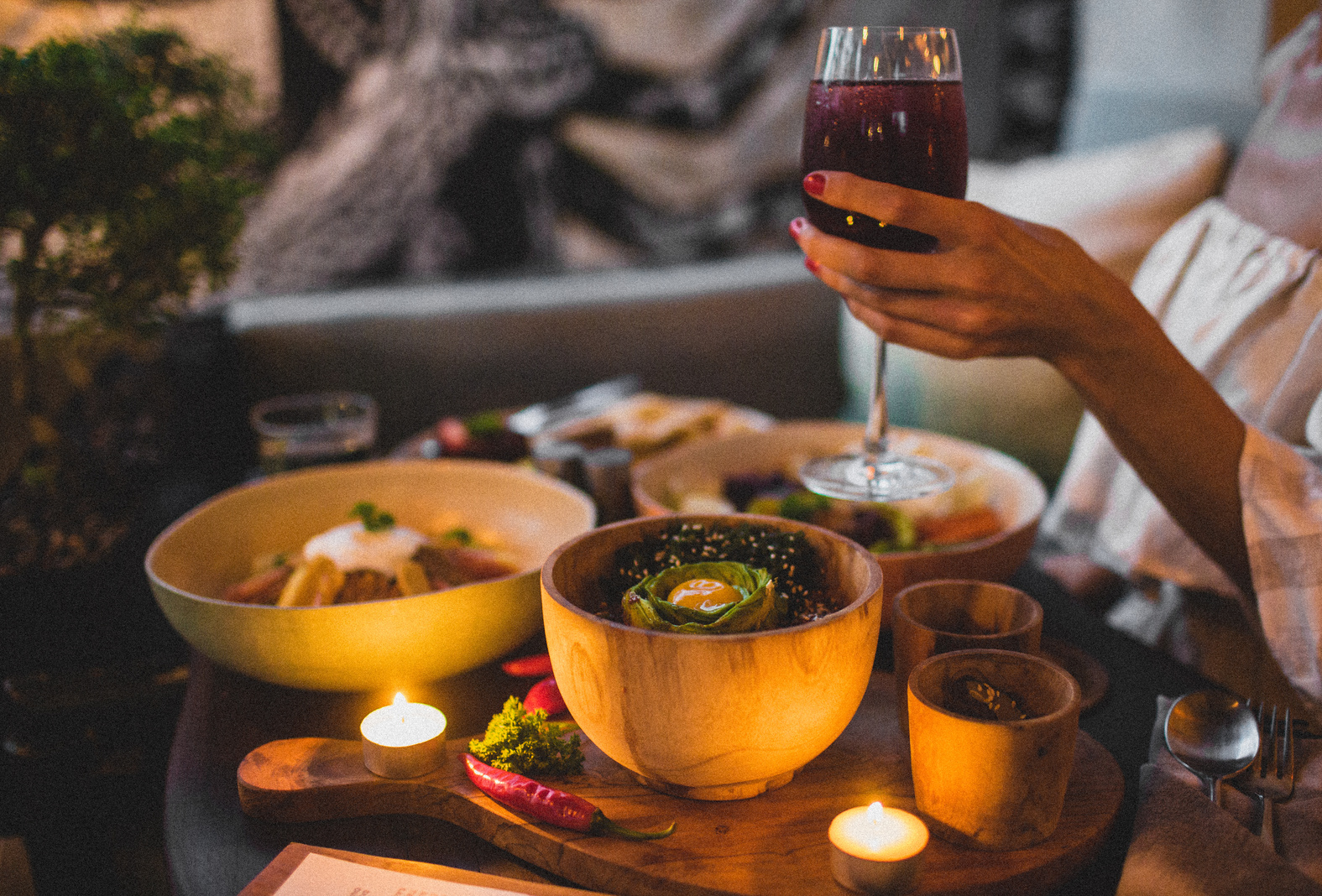 Crop unrecognizable woman with delicious dishes and wine in restaurant